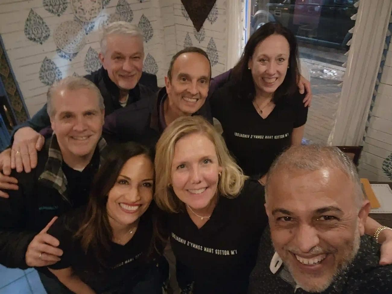 A group of guests wearing “I’m hotter than Sonny’s vindaloo” t-shirts, posing with Sonny